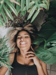 Smiling woman lying down in foliage