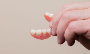 Photo of a hand holding dentures